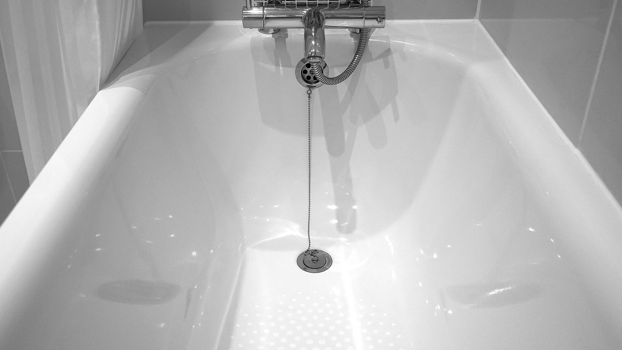 Close-up of a bathtub drain prone to hidden leaks and clogs.